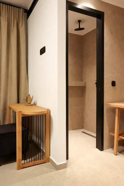 Bathroom entrance with a wooden vanity and linen curtain