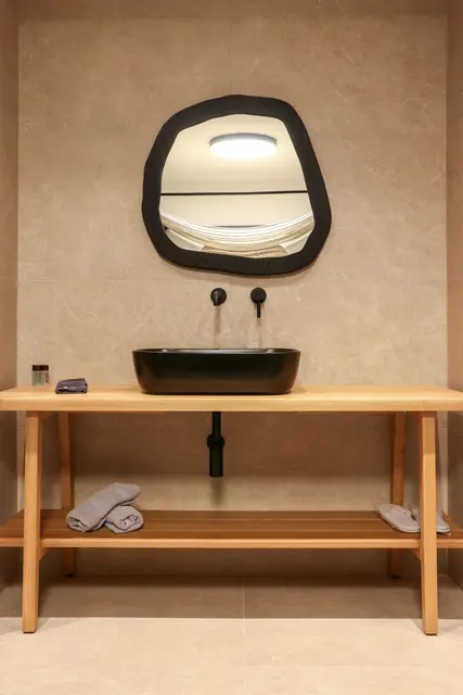 Bathroom vanity with a sculptural black-framed mirror