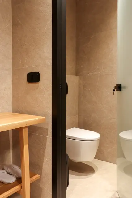 Bathroom with a wall-hung toilet and wooden shelf
