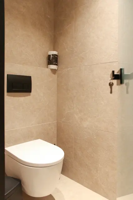 Wall-hung toilet in a bathroom with warm beige tiles