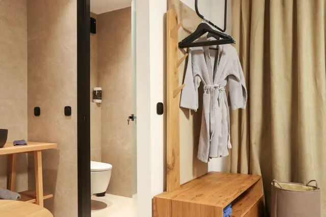 Bathrobe on a hanger beside the bathroom entrance and curtain