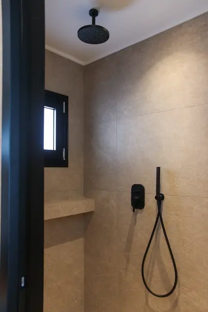 En-suite rain shower with a black hand shower
