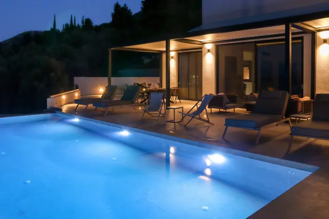 Infinity-style pool lit at night beside the terrace at Villa Ionian Aura