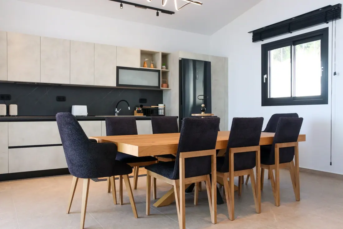 Contemporary fully equipped kitchen with a wooden dining table and dark chairs