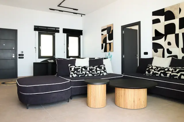 Sofa with patterned cushions and round wooden coffee tables