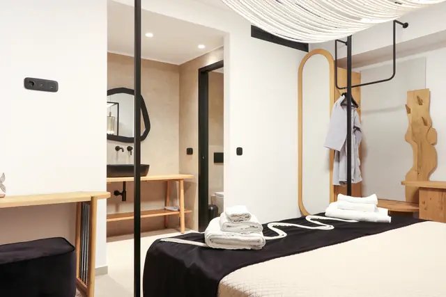 Bedroom with draped canopy ceiling and a black-and-white bed runner