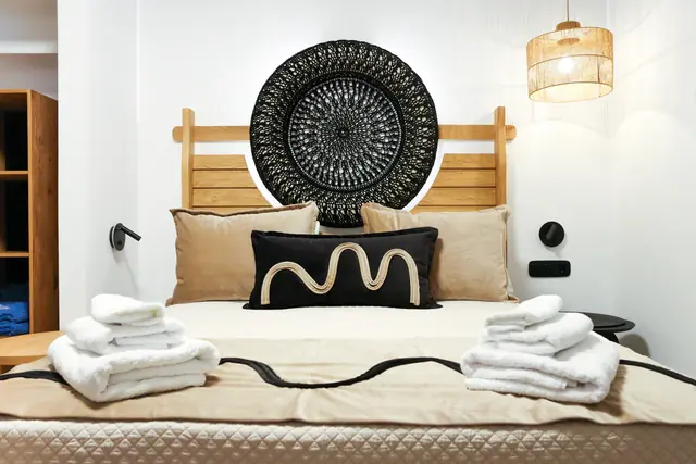Lower-level bedroom with a carved round headboard and folded towels