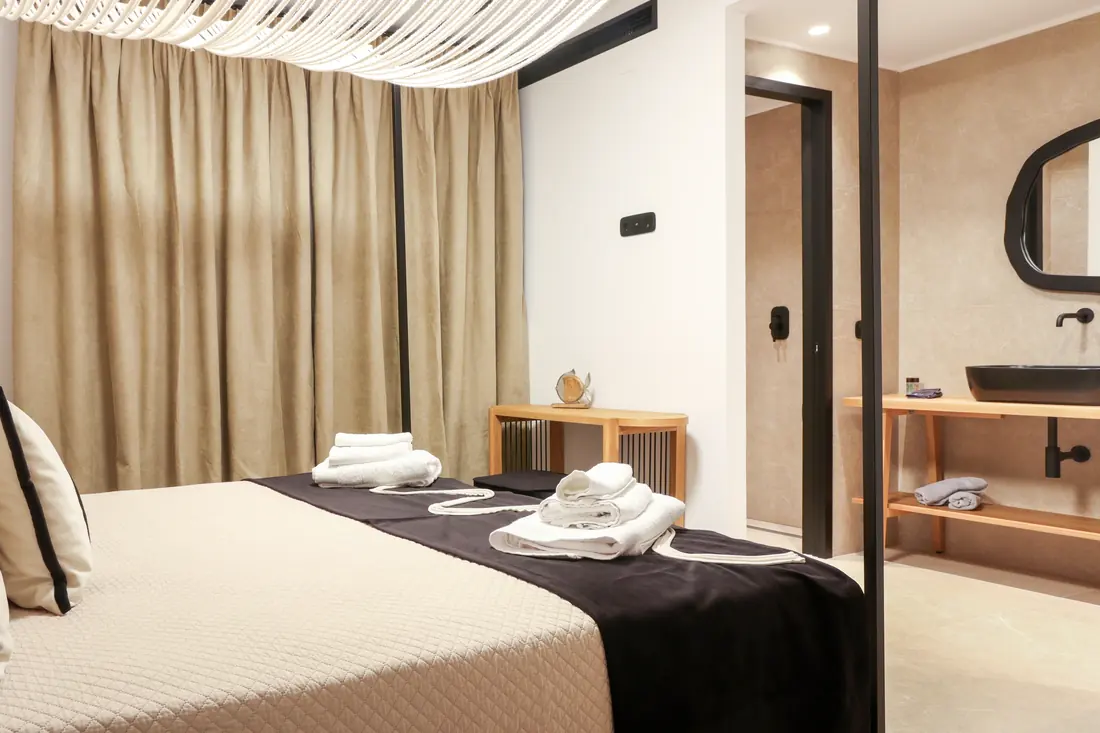 Bedroom with linen curtains, canopy details and folded towels