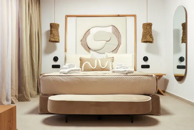 Lower-level double bedroom with an oval mirror and woven pendant lights