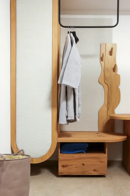 Sculpted wooden clothes rack with a bathrobe in a bedroom