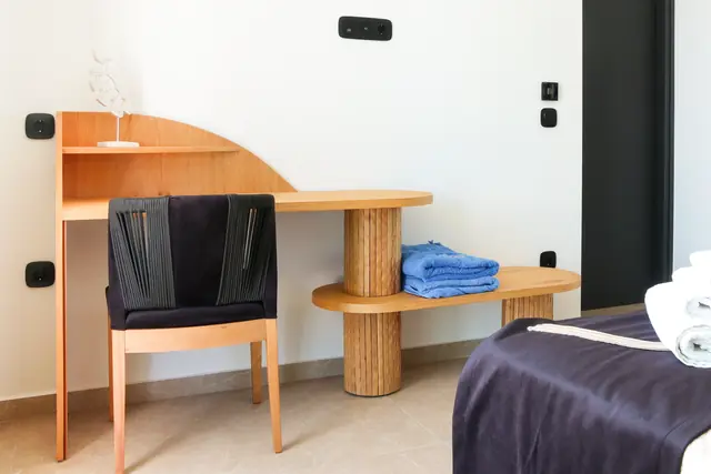 Main bedroom writing desk with a chair and blue towels