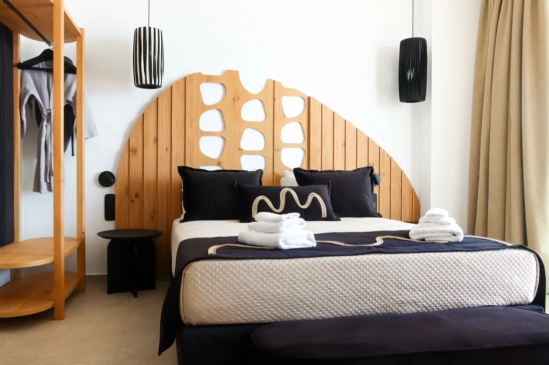 Main bedroom double bed with an open clothes rack and pendant lamps