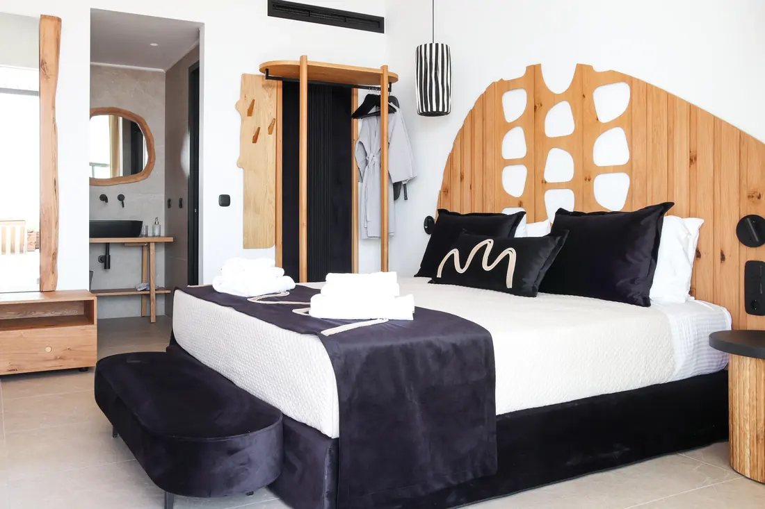 Main bedroom with a double bed and sculpted wooden headboard