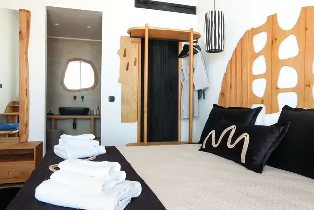 Towels on the main bedroom bed with the en-suite bathroom mirror beyond