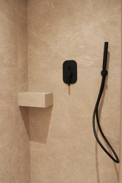 Rain shower with matt black fittings and a stone niche