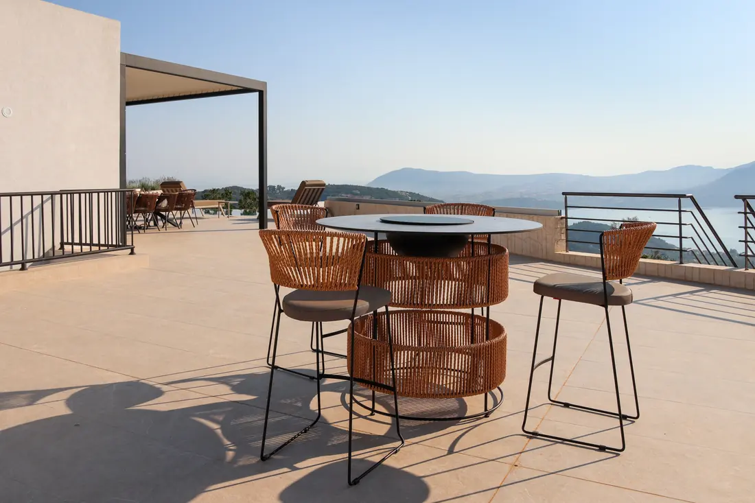 Terrace bar table with high stools and a view over the sea