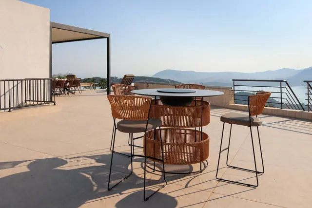 Terrace bar table with high stools and a view over the sea